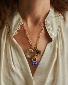 Close-up of a person wearing niki trinity necklace